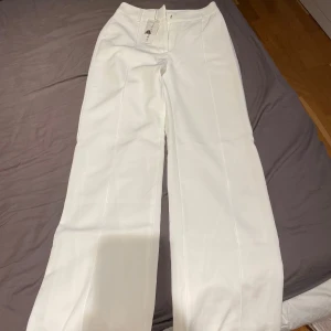 Kostymbyxor  - Vita vida kostymbyxor, aldrig använda, med prislapp och extra spännen. Jag är 166 och de går ner till fötterna