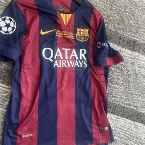 Fc barcelona fotbollströja  - Säljer min fc barcelona tröja då den inte används. Tröjan användes säsongen 14/14 då dom vann trippeln och denna tröja körde dom ucl finalen mot Juventus och Messi bidrog mycket på plan och gjorde även assist till Luis suarez. Den är i storlek M och är i toppskick.  