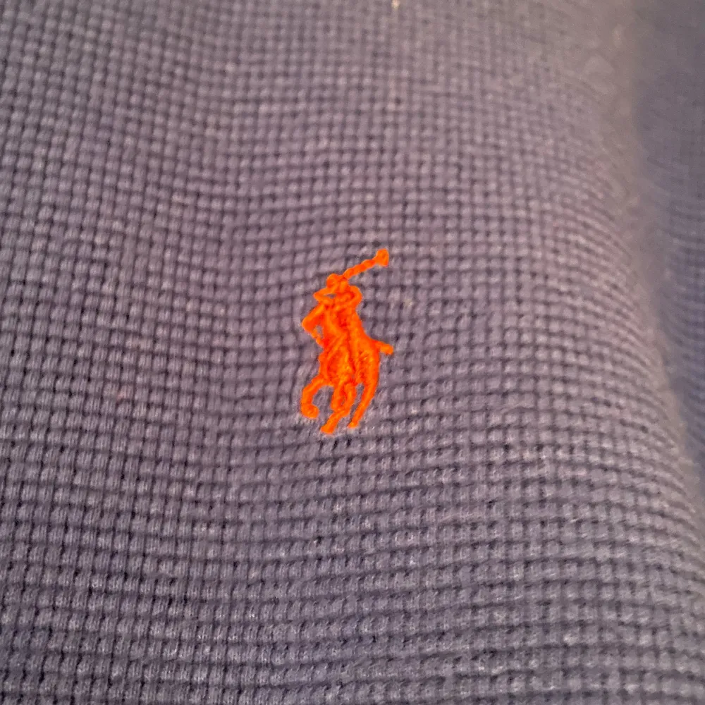 Säljer en snygg blå långärmad tröja från Polo Ralph Lauren. Den är gjord av 100% bomull och har en liten orange broderad logga på bröstet. Perfekt för både höst och vinter. Tröjan är i mycket bra skick och passar perfekt för en avslappnad stil. Använd ett par gånger.. Tröjor & Koftor.