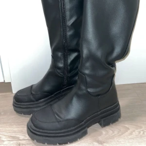 Svarta stövlar med dragkedja - Snygga svarta stövlar i skinn med dragkedja på insidan. Insidan är lätt fodrad för extra värme. Super bra skick, storlek 38. Nypris: 899kr