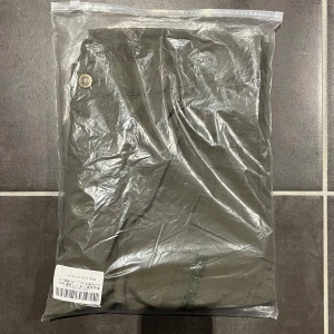 Olivgröna cargopants - Säljer ett par olivgröna cargopants i nytt skick. De har praktiska fickor med dragkedja och knappdetaljer. Perfekta för en avslappnad stil eller utomhusaktiviteter. Materialet verkar vara slitstarkt och bekvämt.