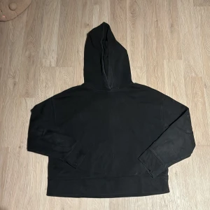 Svart hoodie - Säljer en klassisk svart hoodie i bra skick. Perfekt för kyliga dagar eller mysiga hemmakvällar. Den har en stor huva och långa ärmar, vilket gör den superbekväm. Passar till allt och är ett måste i garderoben!