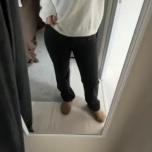 Säljer ett par svarta kostymbyxor i bra skick. Byxorna har knappar som detalj vid midjan, oxh är raka/bootcut