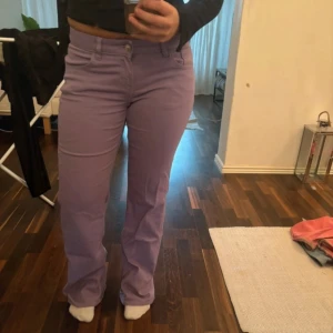 Lila byxor i bootcut-stil - Säljer ett par snygga lila byxor med bootcut. Midjan är medelhög slutar under naveln