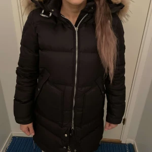Parajumper Long bears Storlek S - Säljer en snygg och varm svart dunjacka från Parajumpers. Jackan har en fluffig pälsfodrad huva och praktiska fickor. Den är perfekt för kalla vinterdagar och har en dragkedja framtill. Superbra skick och redo för nya äventyr! 🖤 Den är i Storlek S 