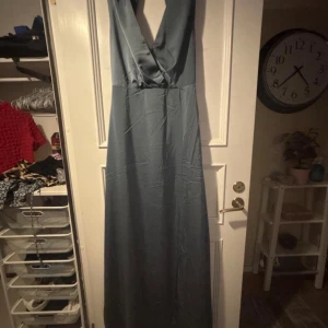 Blå balklänning med v-ringning - Säljer en blå långklänning med stor v-ringning. Klänningen är använd en gång så den är i fint skick! 