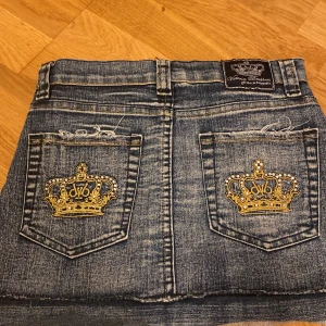 Jeanskjol från Victoria Beckham for Rock & Republic - Säljer en snygg jeanskjol från Victoria Beckham for Rock & Republic i storlek 146/11 år. Kjolen har coola broderade kronor på bakfickorna och en sliten look framtill.  Har använt två gånger. Midjan  31,5 cm! Pris går att diskuteras❤️