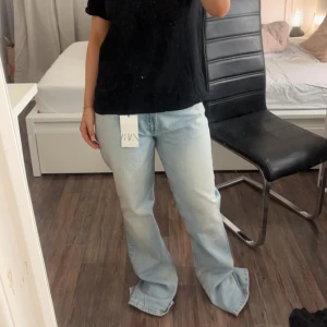 Ljusblå bootcut jeans från Zara - Säljer ett par snygga ljusblå bootcut jeans från Zara i storlek 38. De är helt nya med prislappen kvar. Dom var verkligen perfekta i färgen osv men dom var för stora för mig som egentligen har 38. Är 155 så hade passat någon längre om man inte syr upp dom osv.