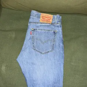 Säljer ett par klassiska blå Levi's jeans i bra skick. De har en slimmad passform och är perfekta för vardagsbruk. Jeansen har den ikoniska Levi's-lappen på baksidan och fem fickor. Perfekta för både höst och vår!