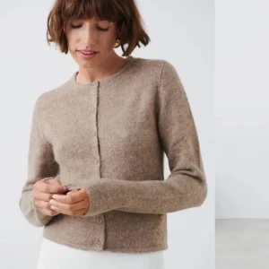 Beige kofta - Säljer en supermysig beige kofta i ullblandning. Den har en klassisk design med knappar framtill och långa ärmar. Perfekt för höst och vinter när du vill hålla dig varm och stilren. Passar både till vardags och lite finare tillfällen. 🧥✨