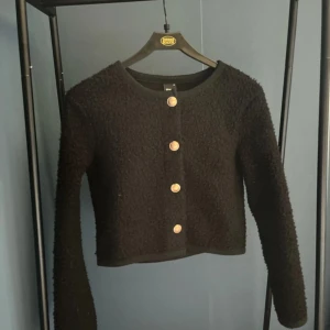 Svart kofta från Gina Tricot - Säljer en snygg svart kofta från Gina Tricot i storlek XS. Den är croppad och har långa ärmar med fina knappar framtill. Perfekt för höst och vinter, och den är i mycket bra skick. Passar både till vardags och fest! 🖤