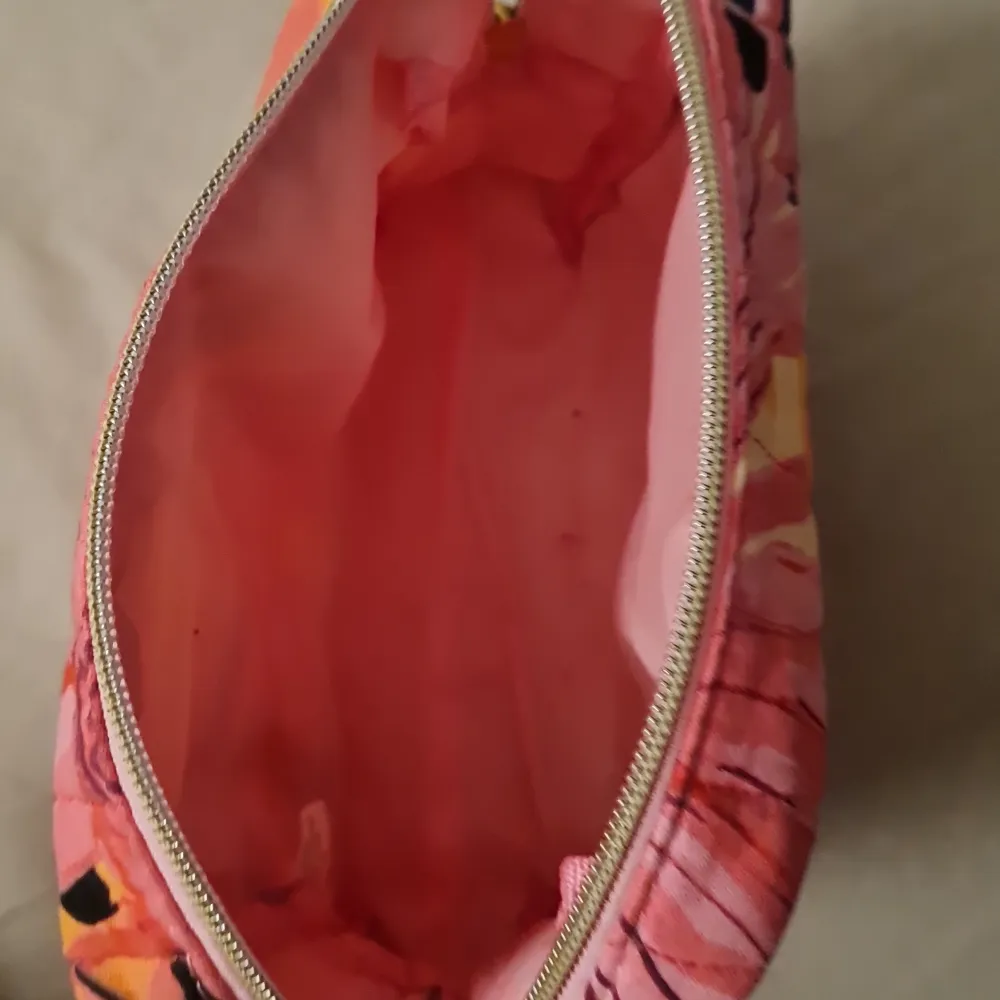 Säljer en superfin och färgglad necessär från Glossybox. Den har ett quiltat mönster i rosa, orange och svart med en praktisk dragkedja. Perfekt för att förvara smink eller andra småsaker. Den är i mycket bra skick och redo för nya äventyr!. Muu.