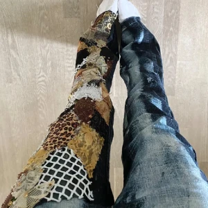 Unika jeans med patchwork och blekt mönster - Säljer ett par unika jeans low waist  med en cool mix av patchwork och blekt mönster. Ena benet har ett färgglatt patchwork med leopard och nätmönster, medan det andra benet är blekt med en häftig effekt. Äkta Stockholmsstil!! ❤️