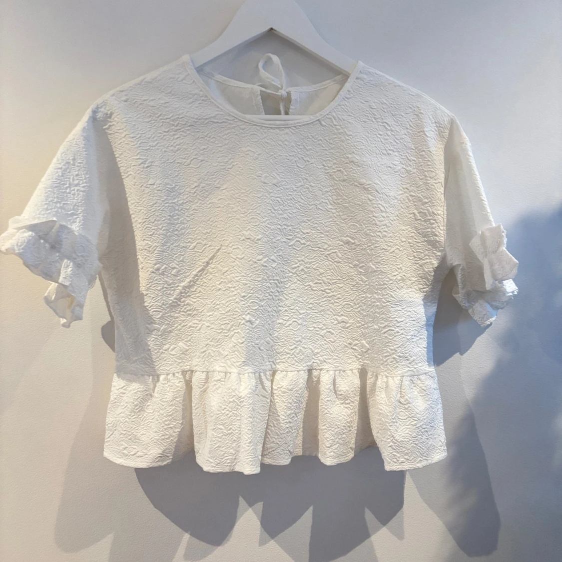 Vit blus med volangdetaljer