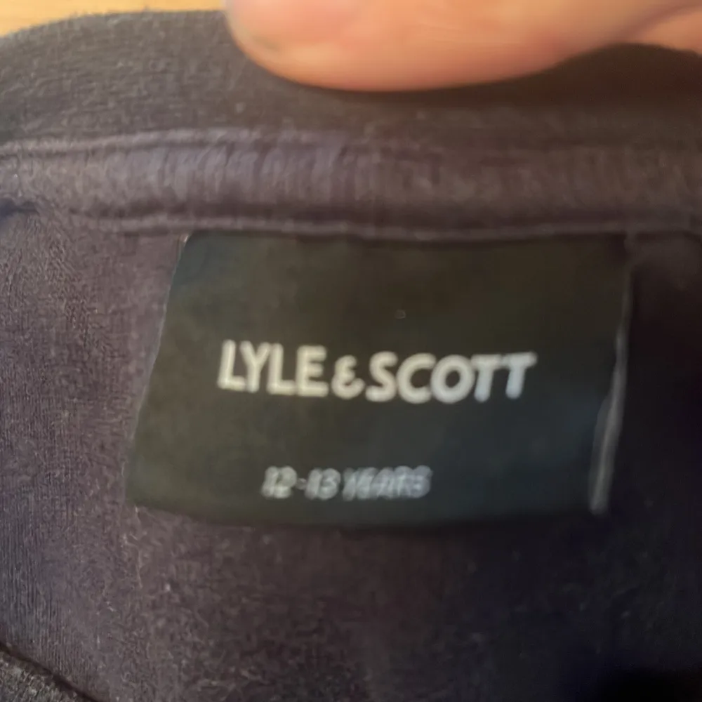 Säljer en snygg mörkblå tröja från Lyle & Scott med deras ikoniska gula logga broderad på bröstet. Tröjan är i bra skick och perfekt för både vardag och lite finare tillfällen. Den är mjuk och bekväm, idealisk för höst och vinter.. Tröjor & Koftor.