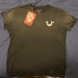 True religion tisha  - Säljer, vintage true religion tisha från början av 2000 talet! Den är helt oanvänd. Den kommer med de originella tagsen. 