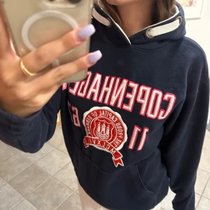 Huvtröja/hoodie - Blå Huvtröja/ hoodie med röd vit text. Väldigt bra kvalité, inte så mycket använd