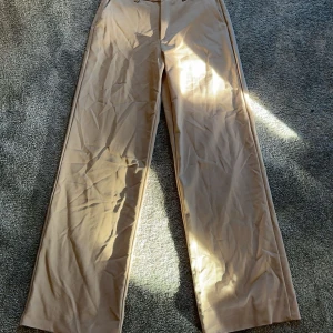 Beiga kostymbyxor i storlek 25 i midjan från IVY - Kostymbyxor från IVY. Dem är uppsydda så sitter bra på en som är 155-162. Använda några gånger, ändå defekten är att ena benet har gått upp i sömmen längst ned (visas i sista bilden). Inte klippta så kan sys i den längd man vill. Nyrpris 1250.