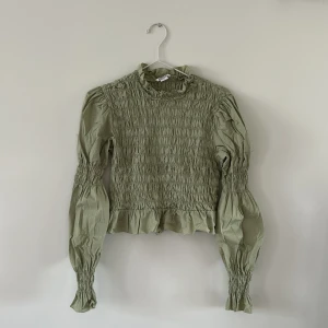 Topp Monki - En kortare topp i ljus grön färg från Monki. Mycket stretch i materialet. Storlek M. 