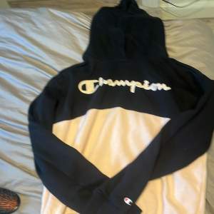  I nyskick champion hoodie ljusrosa och svart champion text precis vid bröstet i skrivstil 