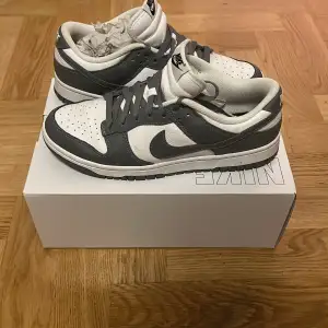 Säljer ett par snygga Nike Dunk sneakers i grått och vitt. De har en klassisk design med snörning och är i nyskick. Perfekta för både vardag och fest! Köptes för 1400 från nike. Har bara använt 1-2 gånger. Vid snabb affär 950kr