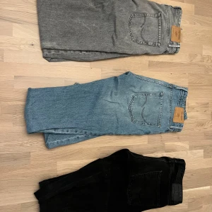Jack n Jones jeans  - Tjena, nu äre dags för mig att sälja mina Jack n Jones byxor. De blåa och svarta är knappt använda och har inga tecken på användning medans de gråa har en liten slitning på ena benet som syns på bild 3(50 kr för de gråa)  Blåa,svarta: 32/34 Grå:31/34