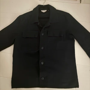 Sandö overshirt - Tja, säljer denna riktigt feta mörkblåa overshirten från Sandö. Den är använd cirka 2 gånger och är i storlek 48(s/m)!  Nypris:1300 kr, mitt pris 1000 kr! Priset är diskuterbart endast vid snabb affär!