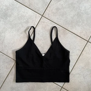 Svart omlottlinne från FB Sister - Säljer ett svart omlottlinne från newyorker i storlek XS. Linnet har smala axelband och en stilren omlottdesign. Perfekt för både vardag och fest! skriv vid frågor💗