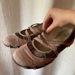 Rosa y2k balettskor - Trendiga balettskor i grårosa färg + mönster och med spännen och allt.  Storlek 38 🌺 Innersulorna och hälarna är ganska smutsiga, det går säkert att tvätta bort. Utöver det är skorna i bra skick och väldigt fina tycker jag ❣️