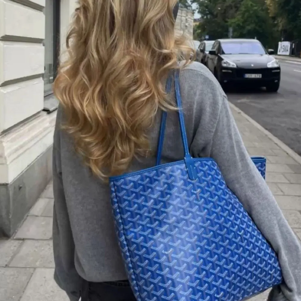 Säljer min jättefina Blåa Goyard väska, den är i nytt skick och har knappt använts. Den luktar ej och har inga skador överhuvudtaget. Får plats en stor data och böcker. Den gula påsen är sönder skickar med den om man vill ha den. Sista bild är ej min. Väskor.