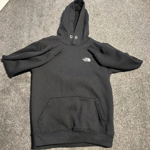Svart hoodie från The North Face - Säljer en svart hoodie från The North Face. Den är superbekväm och perfekt för kyliga dagar. Hoodien har en klassisk design med en stor ficka fram och justerbar huva. 