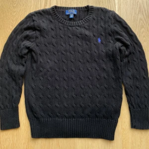 Ralph Lauren tröja  - Säljer en skitsnygg stickad tröja från Ralph Lauren. Med färgerna svart och mörkblå. Säljer eftersom den är för liten. Köpt på NK för runt 1199kr. NK påse ingår i köpet, kvittot har jag slarvat bort. Tröjan passar 150-160. skick: 9/10. Pris kan disku
