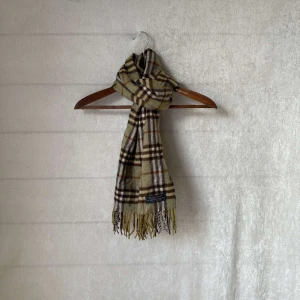 burberry halsduk - Säljer halsduk från Burberry i färgen mörk grön, brun och grå. Den är gjord av mjuk kashmir och lammull. Perfekt för att hålla sig varm och stilren under kyliga dagar. Passar både höst och vinter! Skicket är 9/10 utan defekter och såklart äkta👍 hör av dig vid frågor👍