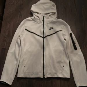 Nike tech fleece hoodie  - Vit Nike tech hoodie i nyskick 👀 ändast använd ett fåtal gånger! Köpt från Unisport för ca 1100 🤠 Storlek: S, funkar också om man brukar ha M ! 