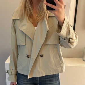 Trenchcoat  - Snygg trenchcoat från Esprit, endast använd ett fåtal gånger. Nypris 1200kr men säljer för 300kr Färgen är grön/beige