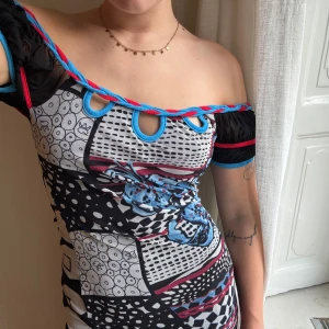 Mönstrad offshoulder klänning från Save the Queen! - Säljer en unik och färgglad offshoulder klänning från Save the Queen. Klänningen har ett coolt geometriskt mönster i svart, vit, blå och röd. Den är tight och perfekt för fester. Materialet känns bekvämt och stretchigt. Passar perfekt för dig som vill sticka ut! Är en L men passar mig som är en M. Dock förmodligen även en L då den är väldigt stretchig!