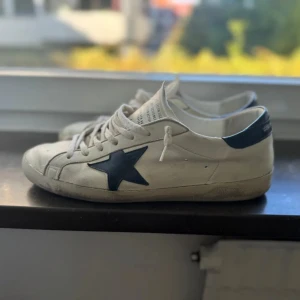 Golden goose skor - Tjena! Säljer dessa golden goose skor i ett superskick (skick 9/10)! Allt OG medföljer! Det vill säga box, påse och äktighets bevis! Prutat och klart! Skorna är i storlek 43 men passar också 44. Finns ett pyttelitet slitage på hälen, som ej syns (se sista bilden). Om du har frågor är det bara att skriva!🤝🏼 /Vidar🏄‍♂️