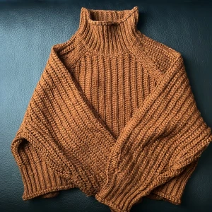 Brun stickad polotröja från H&M - Säljer en supermysig brun stickad polotröja från H&M. Perfekt för höst och vinter. Tröjan har en ribbad design och en hög polokrage som håller dig varm. 🧡