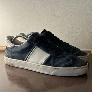 Valentino Flycrews - Säljer dessa marinblå valentino Flycrews i storlek 41, de har blivit lagade på framsidan därmed är lite torkat lim synligt. Skicket är 6/10 och de saknas 7 av 22 nitar.  Vid frågor är det bara skicka ett DM