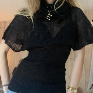 Svart stickad topp - Säljer en svart stickad topp med korta ärmar och hög krage. Toppen har en tight passform med ribbad midja som framhäver figuren. Perfekt för en stilren look. BRA kvalitet❤️❤️