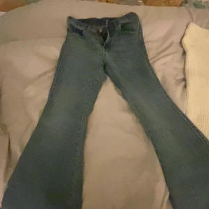 Jeans  - Snygga blå jeansbyxor med en klassisk design. De har en normal passform och är perfekta för en avslappnad stil. Byxorna har fickor både fram och bak samt en dragkedja och knapp framtill.