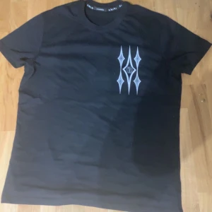 Svart t-shirt från Amiri - Snygg svart t-shirt från Amiri med unikt tryck i vitt på både fram- och baksidan. Perfekt för en stilren look med en twist. T-shirten har en klassisk passform och är kortärmad.