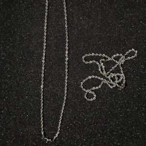 Silverfärgad cordell kedja - Snyggt silverfärgat halsband med en elegant tvinnad kedja finns i 2 storlekar 50,55cm 3 mm bred. Perfekt för att ge en stilren touch till din outfit. Kedjan har en enkel och klassisk design som passar till många olika stilar.