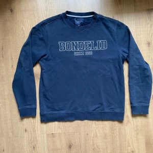 Mörkblå sweatshirt från Bondelid - Hej, säljer en stilren mörkblå sweatshirt från Bondelid med tryck 'Bondelid Since 1956' på bröstet. Stlk S. 