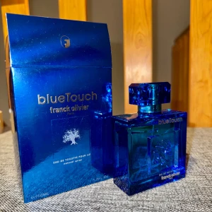 Blue Touch EDT från Franck Olivier - Blue Touch från Franck Olivier är en Eau de Toilette för män med en fräsch och aromatisk doftprofil. Flaskan är fyrkantig och helt i blått glas med en matchande blå kork. Doften har inslag av citrus, gröna noter, trä och mysk, vilket ger en uppfriskande och maskulin känsla. Oanvänd.