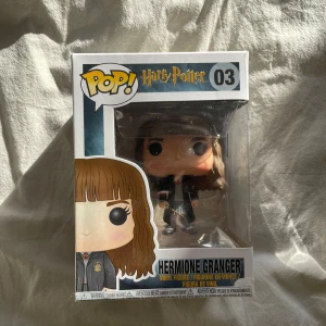 Hermione Granger Pop! Vinylfigur - Säljer en Pop! vinylfigur av Hermione Granger från Harry Potter-serien. Figuren är i en snygg förpackning med nummer 03 och visar Hermione i sin klassiska Hogwarts-uniform. Perfekt för samlare och Harry Potter-fans! Öppnad en gång. 