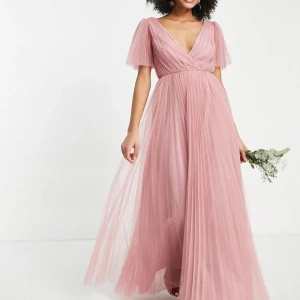 Rosa balklänning - Superfin rosa balklänning i tyll från Asos. Klänningen är v-ringad fram och har en satinrosett samt knappar i ryggen. Använd endast en gång. 