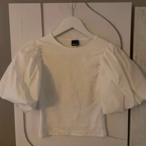 Vit topp med puffärmar och öppen rygg - Säljer en vit topp från Gina med puffiga kortärmar och öppen rygg. 