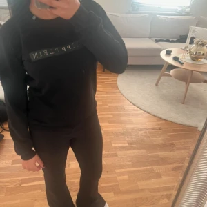 Svart tröja från Philipp Plein - Snygg svart tröja från Philipp Plein med logga på bröstet och en detalj på ärmen. Perfekt för en stilren look. Tröjan har långa ärmar och en klassisk passform.