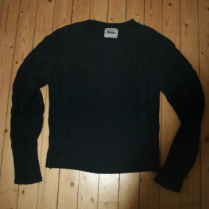 Mörkblå stickad tröja från Acne studios - Säljer en snygg mörkblå stickad tröja från Acne. Tröjan har ett klassiskt flätmönster och långa ärmar. Riktig acne studios tröja i perfekt skick. Tröjan är insydd se bild 3 men jag har gjort det så det inte synns, nu passar den bra till storlek s, innan passade den s vid brösten men inte vid midja.